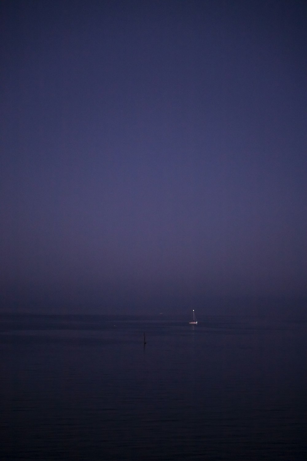 body of water under gray sky at night