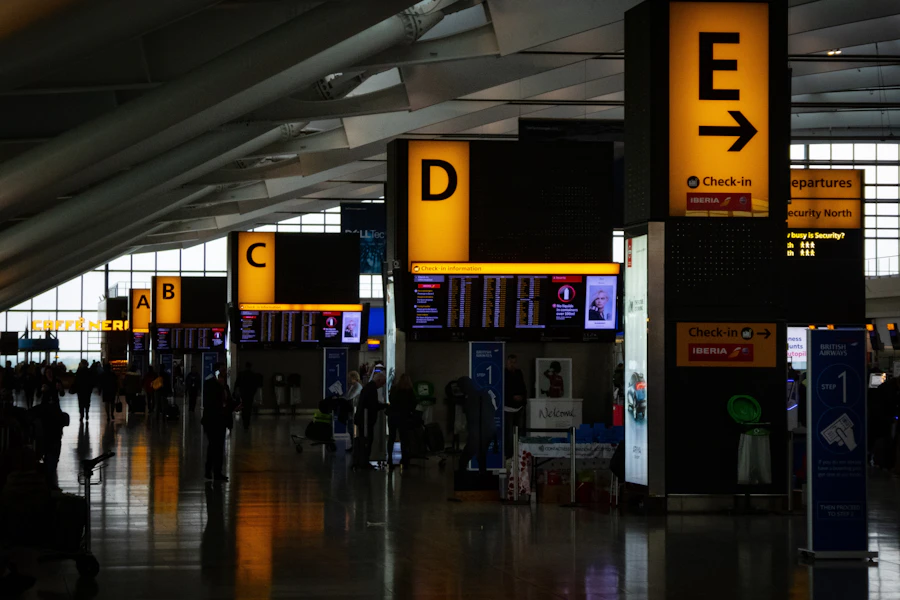 Airport departures hall with illuminated overhead check-in signs marked A through E