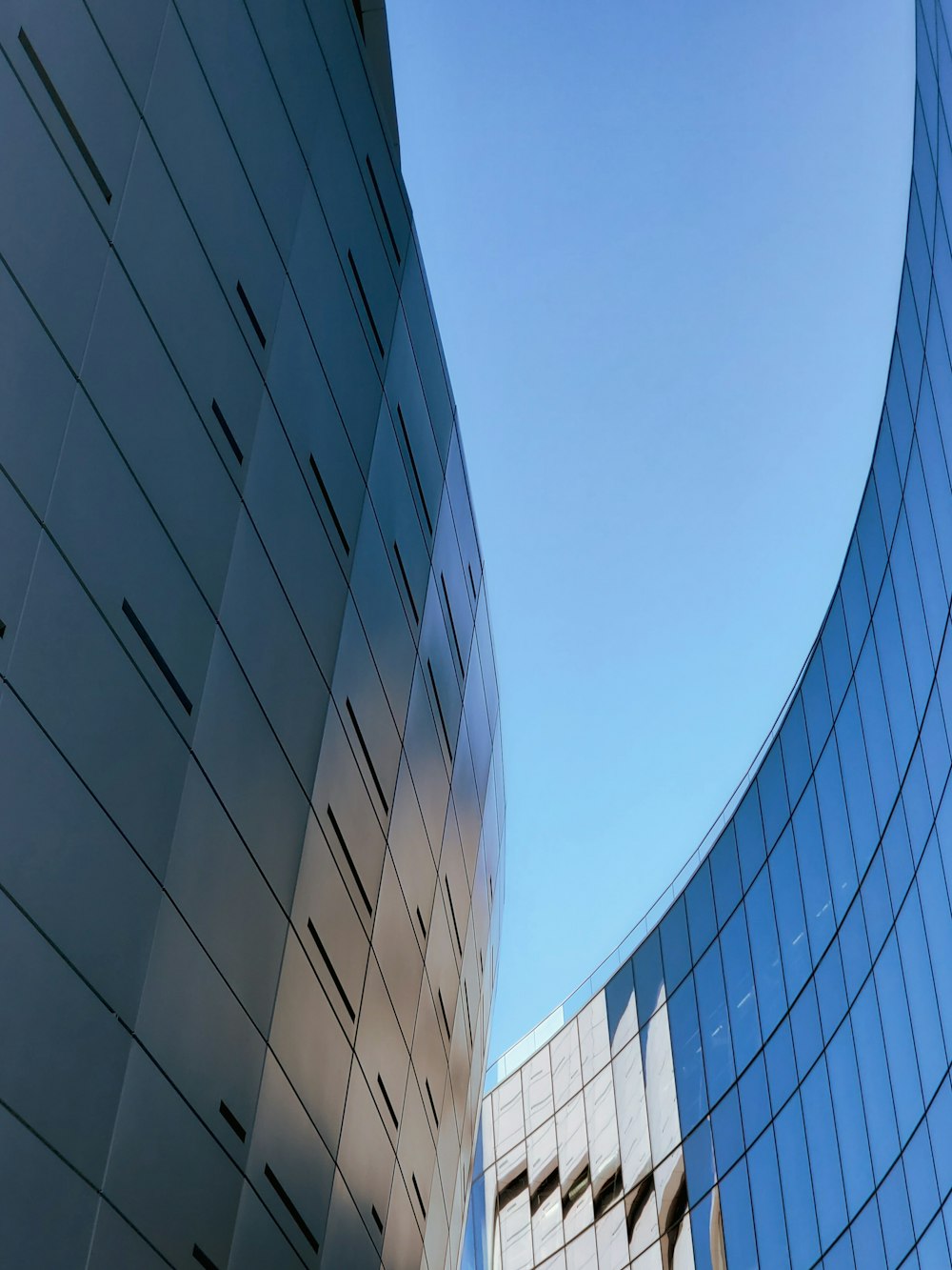 low-angle photography of blue glass walled building during daytime