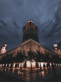 people walking near brown historic palace during night time