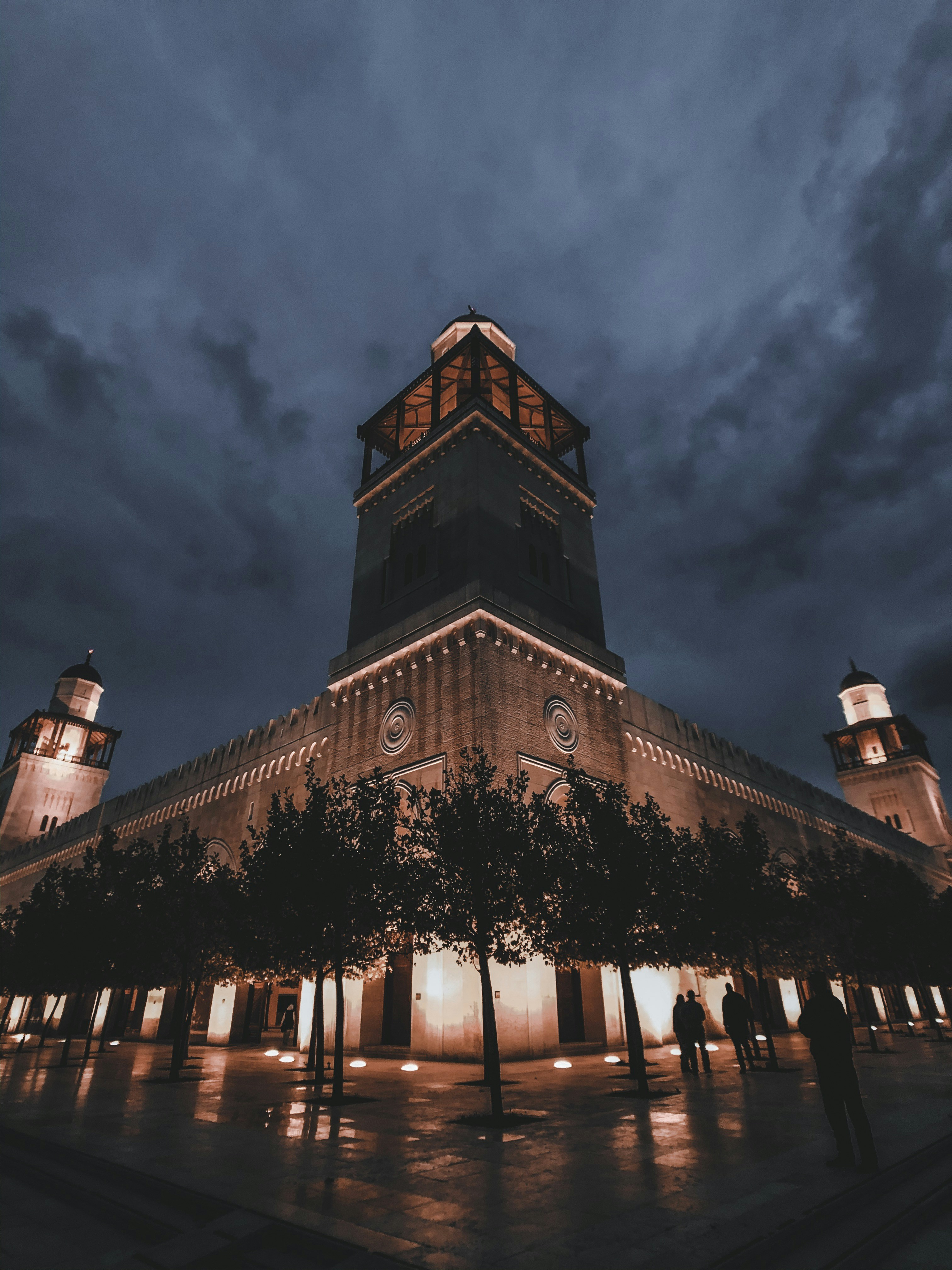 people walking near brown historic palace during night time