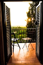 Sunlit balcony with chairs facing the river, inviting guests to enjoy morning coffee.