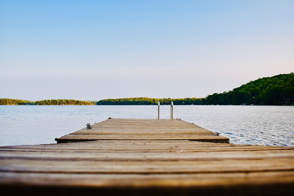 brown wooden dock on calm body ofwater
