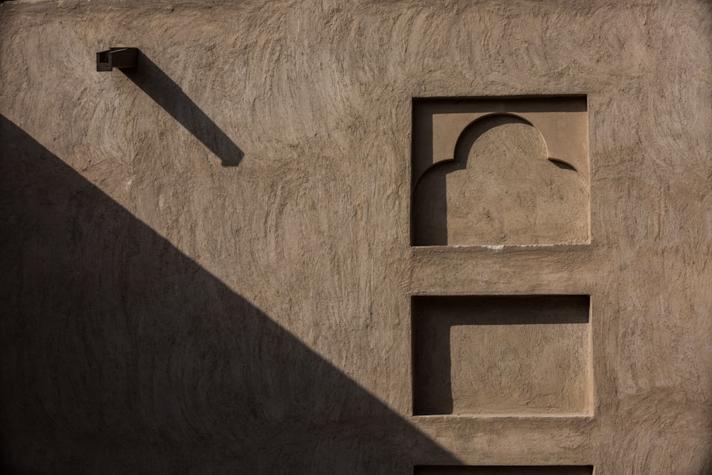 the shadow of a building on a wall