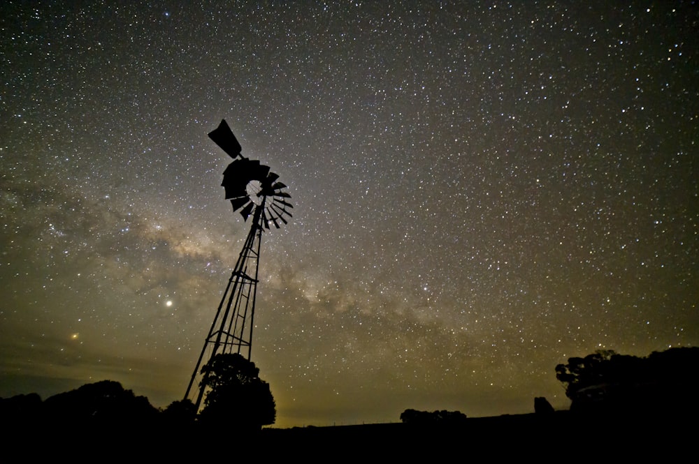 silhouette of windmill under starry sky