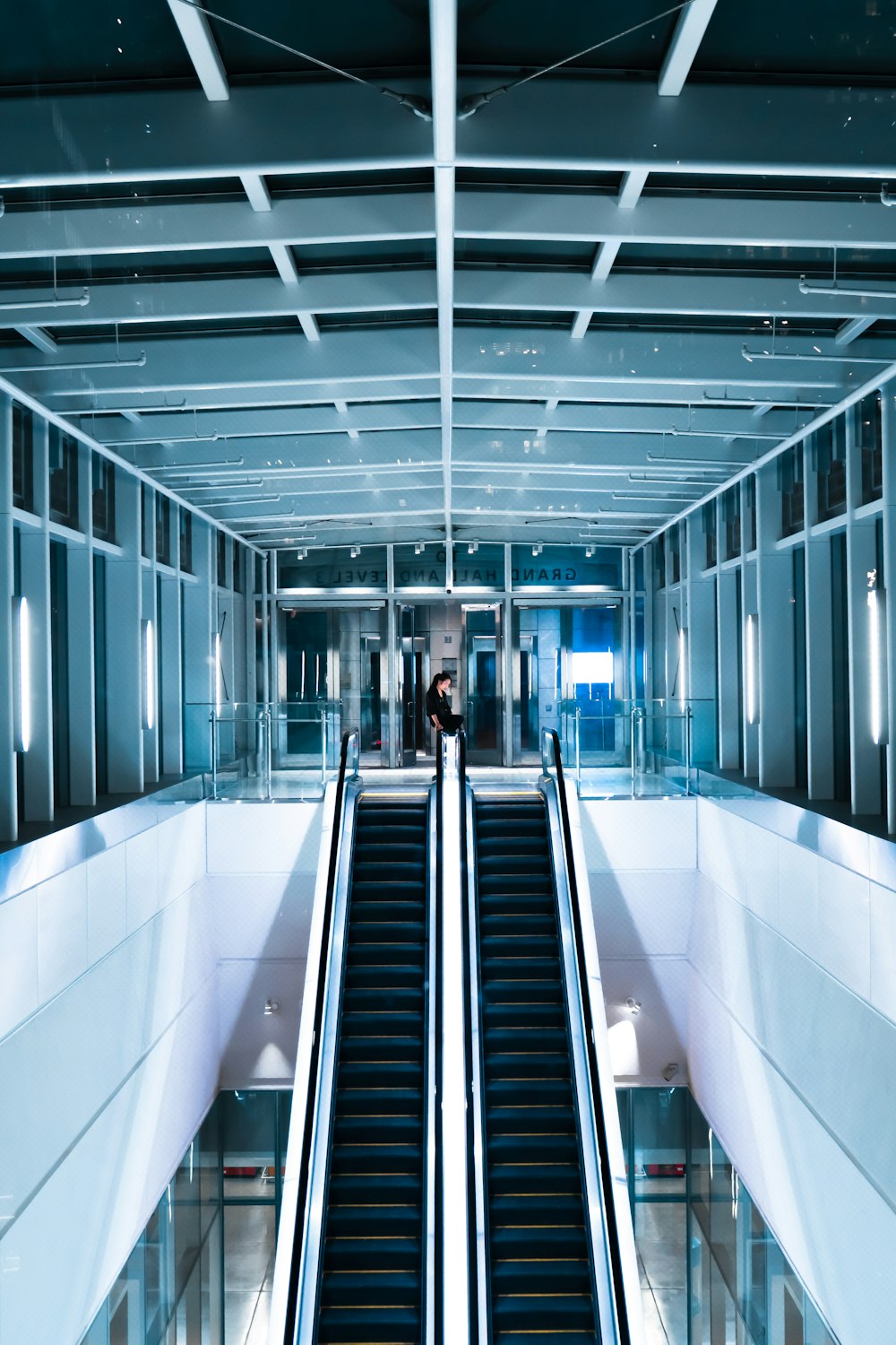 person in black shirt standing beside escalator