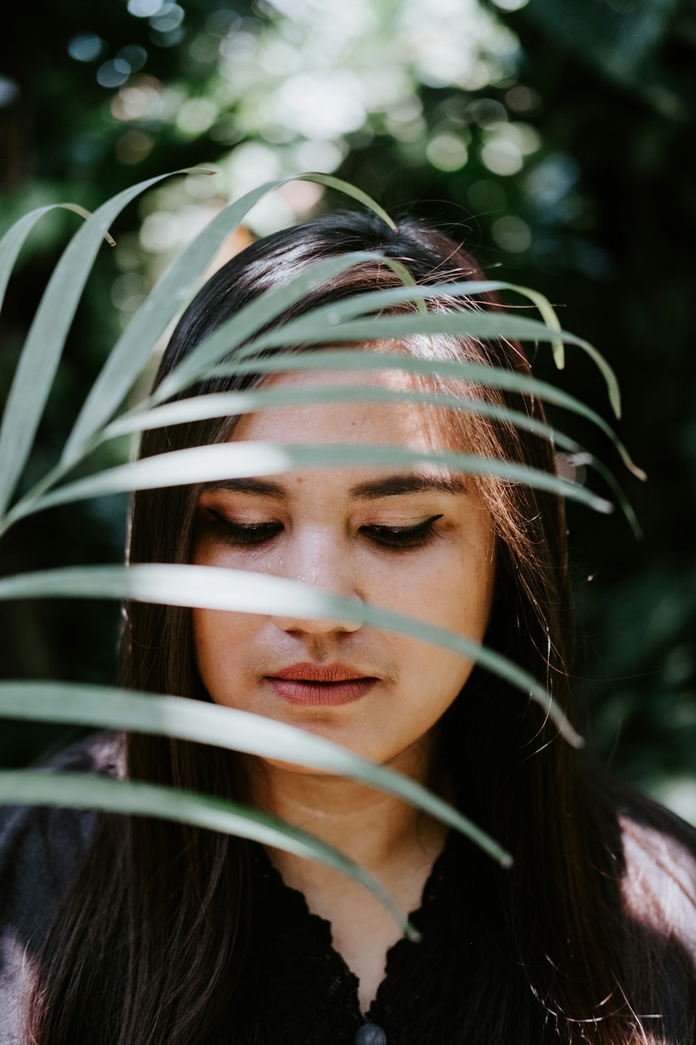 woman wearing black top near green leaf plant