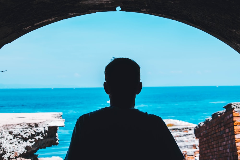 silhouette of man standing under arch