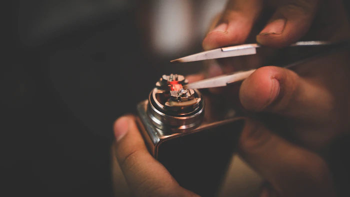 Person assembling and maintaining a vape box mod
