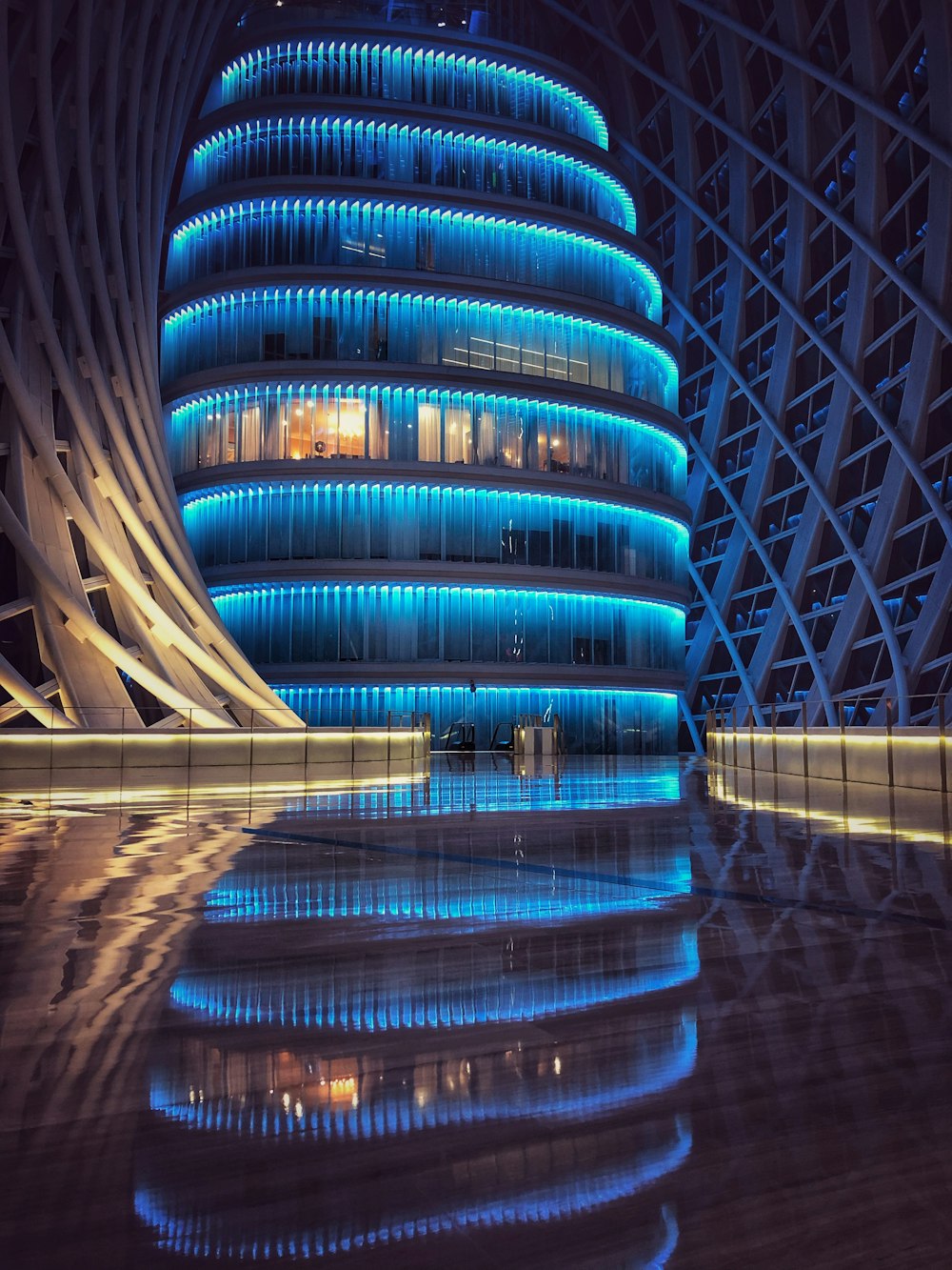 blue lighted glass building inside metal frame building