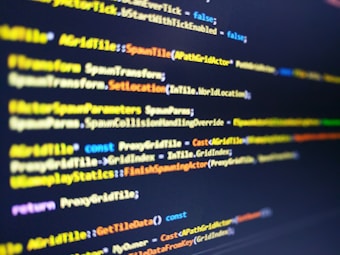 A close-up shot of computer code displayed on a monitor. The code syntax includes keywords and commands typically used in programming, with varying colors like yellow, blue, and white for different elements. The image has a shallow depth of field with the focus on the central portion of the script.