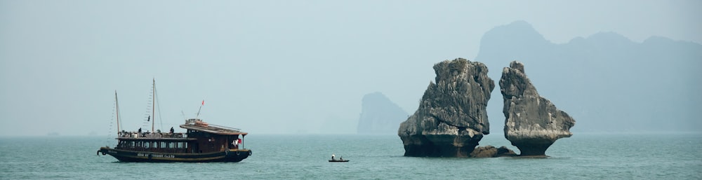 brown boat near rock formation