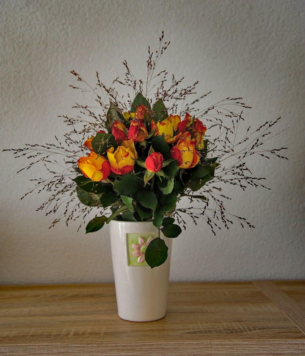 pink and yellow flower arrangement in white ceramic vase