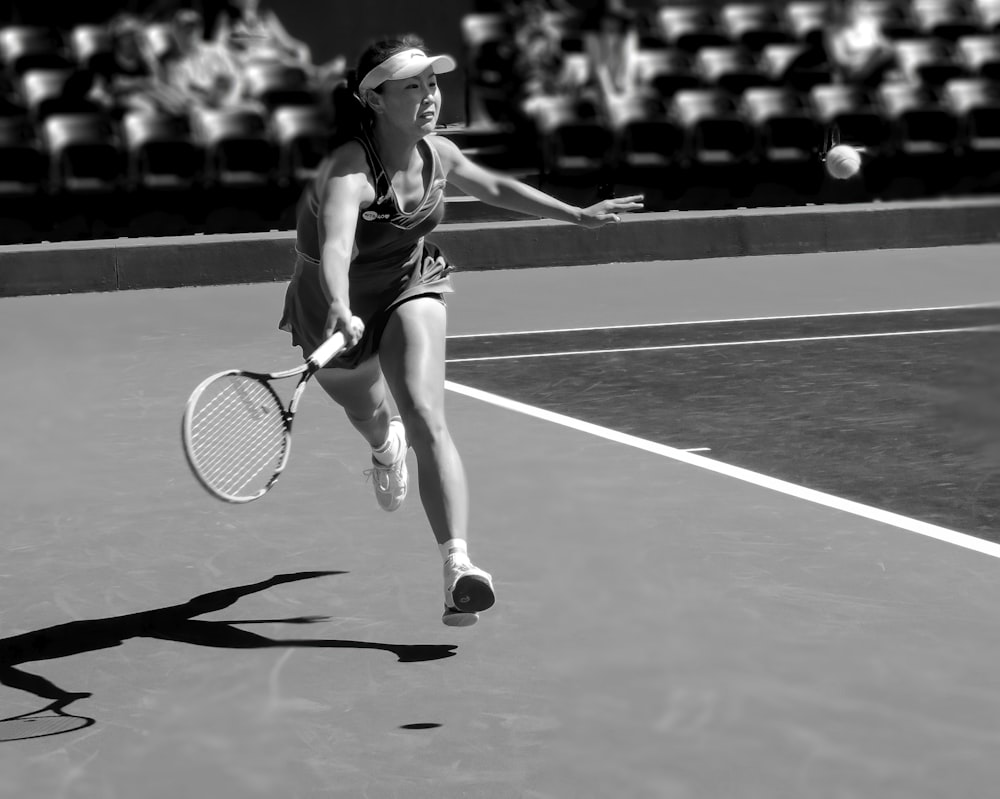 grayscale photo of woman playing tennis