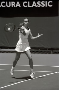 A tennis player using the handrills device on court, focusing on perfecting forehand technique.