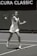 A tennis player wearing a white outfit is captured mid-action on a tennis court, preparing to hit a ball with a forehand stroke. The background shows a banner with the text 'Acura Classic.' The image is in black and white, highlighting the player's focus and motion.
