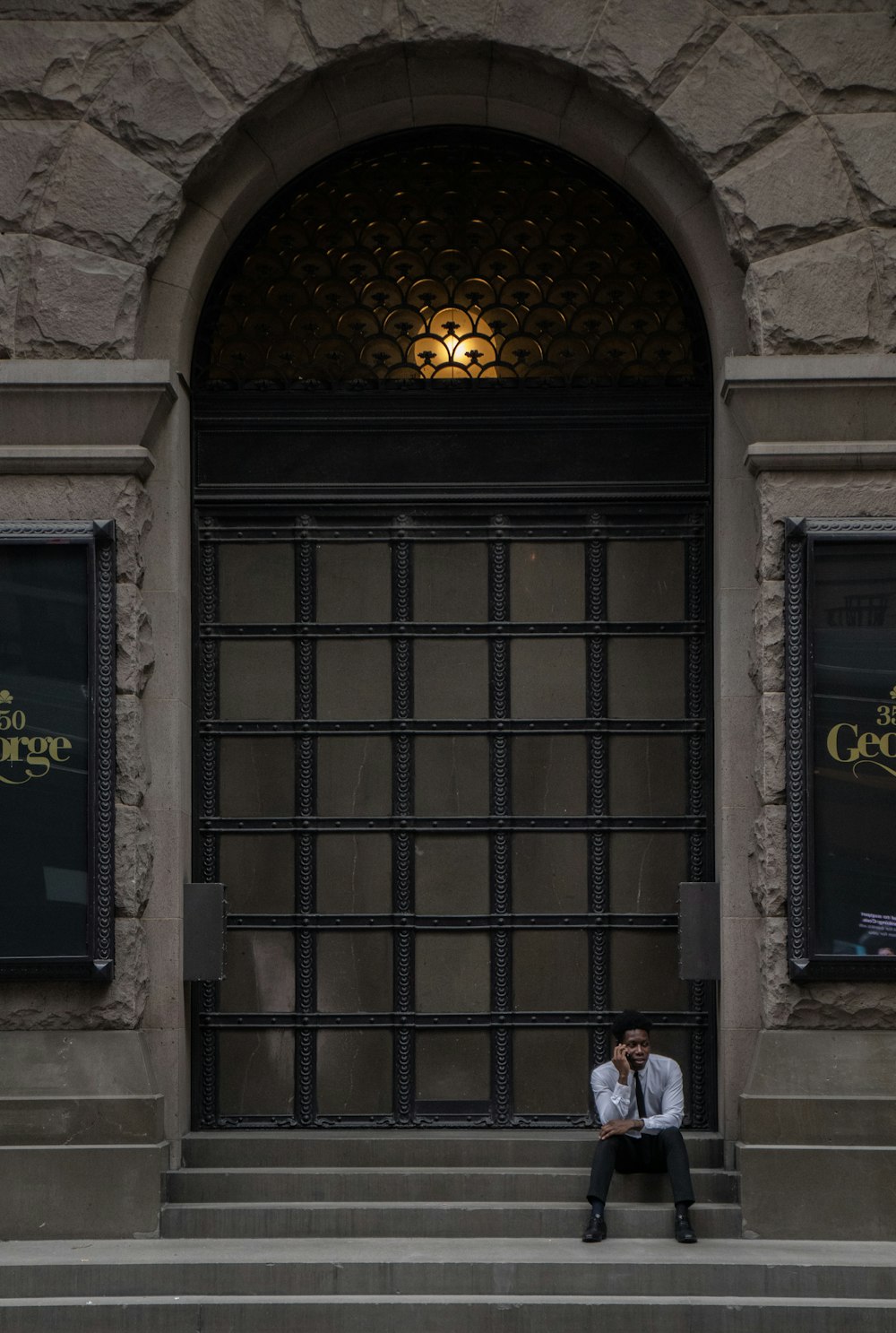 man sitting on stairs in front of door