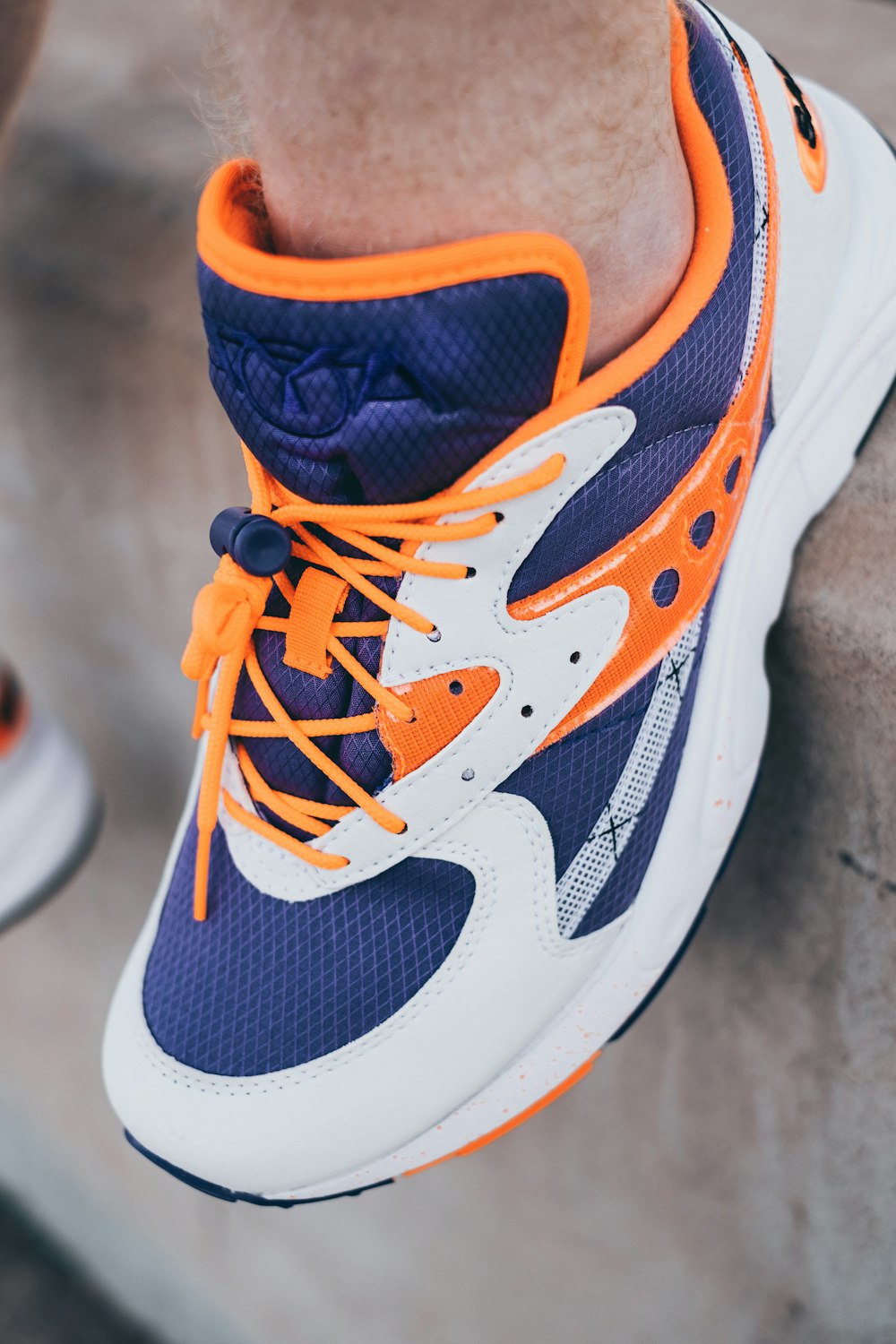 unpaired blue, white, and orange Saucony sneaker