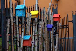 Colorful array of birdhouses hanging on wooden display racks