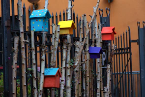 Colorful array of birdhouses hanging on wooden display racks