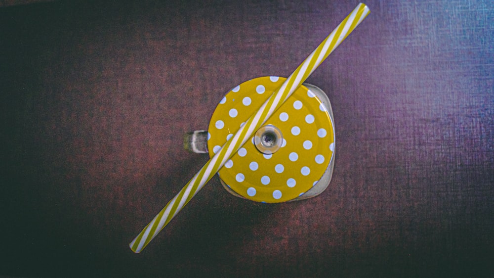 white and yellow striped straw on top of clear glass mug