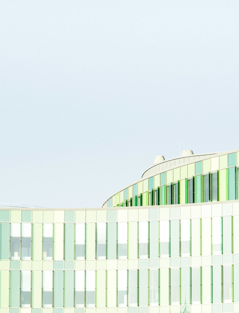 green glass building under white clouds