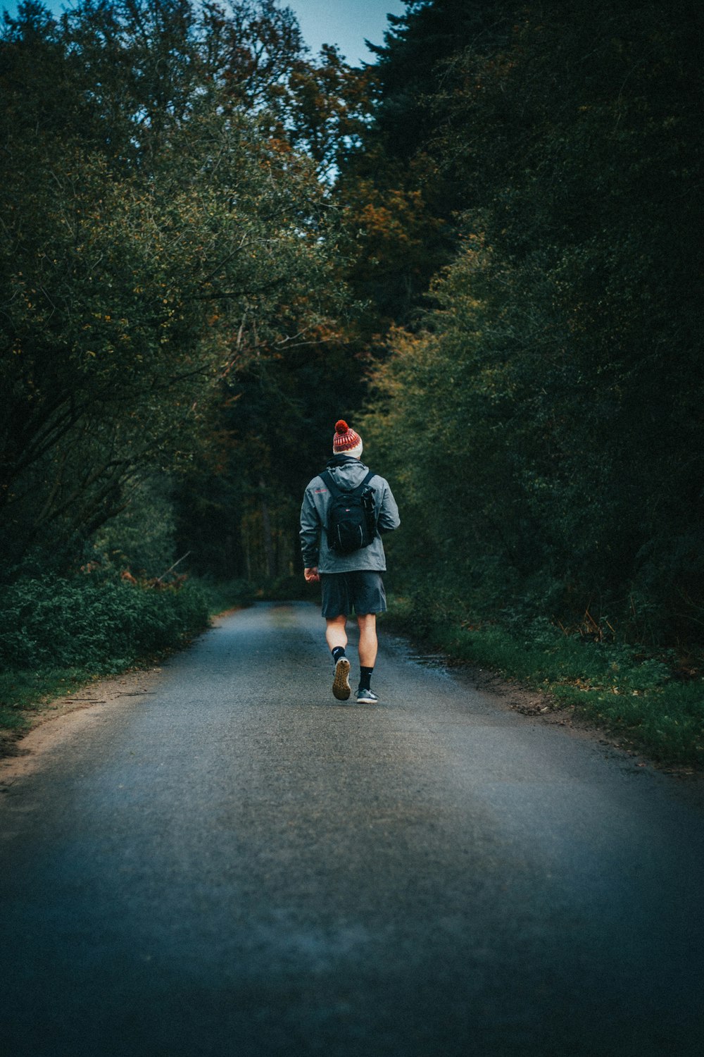 man walking on road during daytime