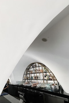 A sleek, modern custom mini bar with colorful bottles and elegant glassware arranged neatly.