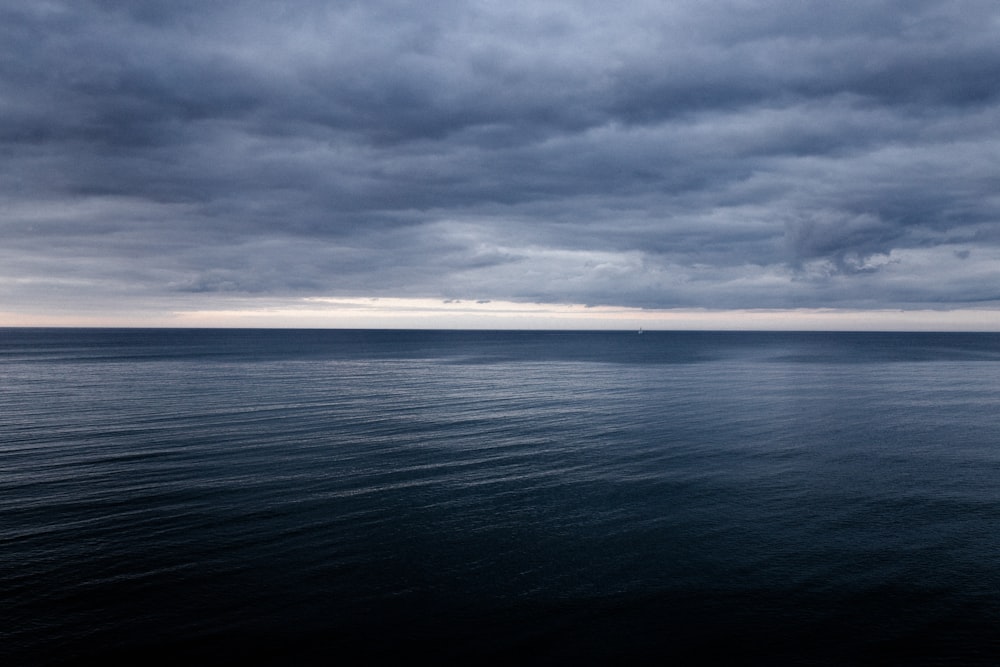 fotografia di paesaggio del mare blu sotto un cielo drammatico