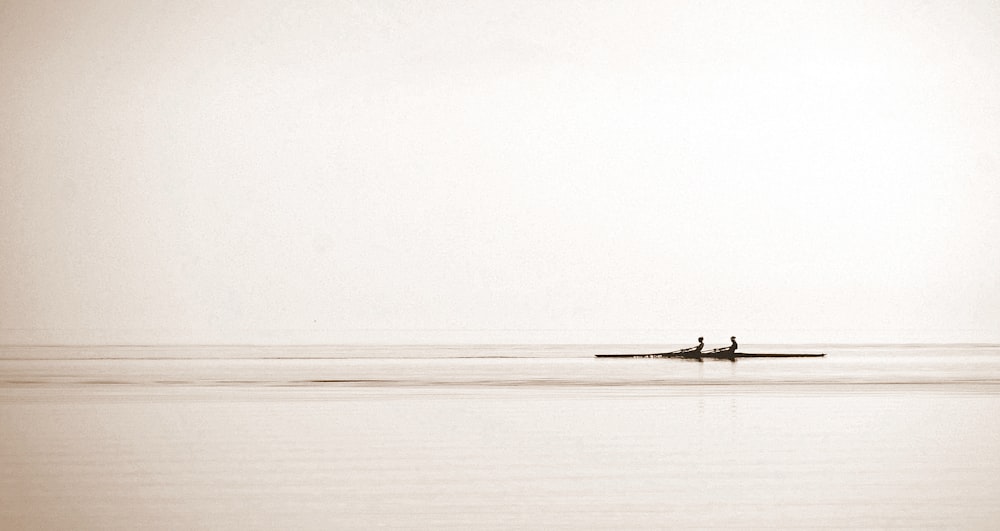 two people in a boat on a large body of water