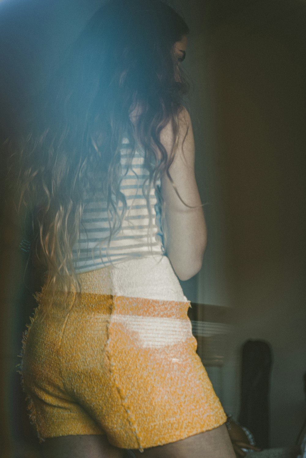 woman wearing white and gray striped sleeveless shirt and orange shorts