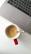 coffee filled mug by laptop