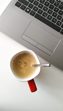 coffee filled mug by laptop