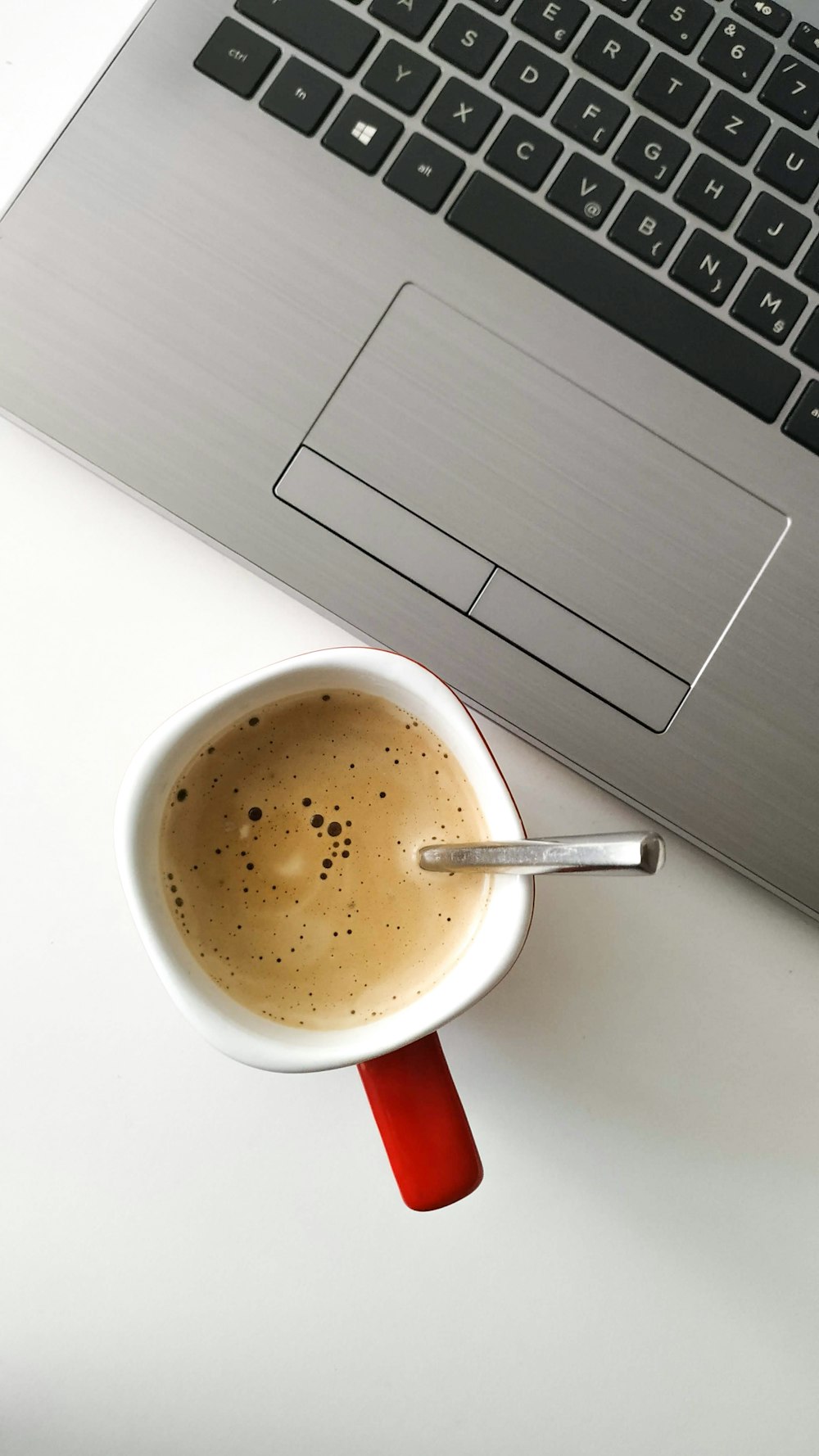 taza llena de café por computadora portátil