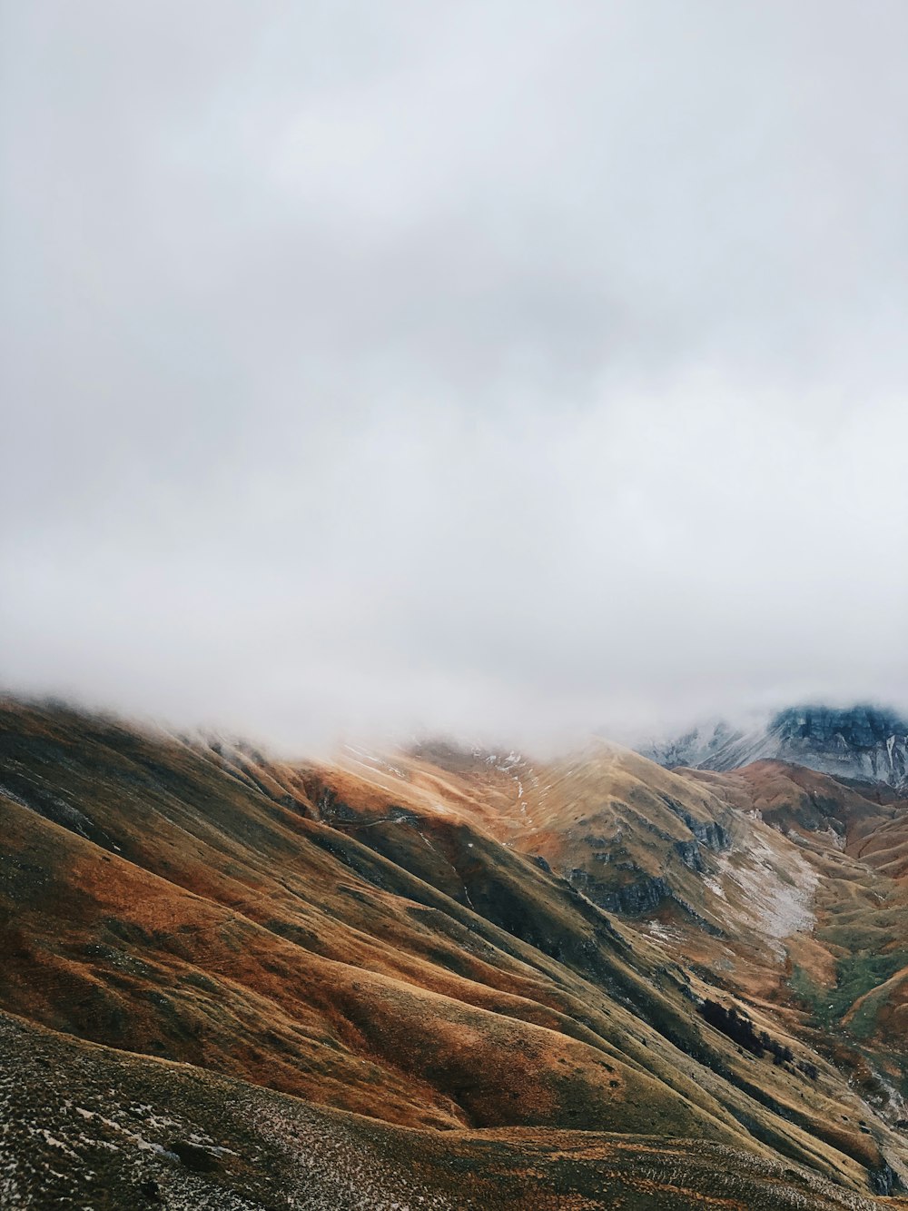 scogliera di montagna sotto il cielo bianco durante il giorno