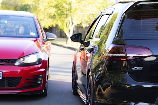 Two used cars parked side by side on a sunny day, highlighting their exterior differences.