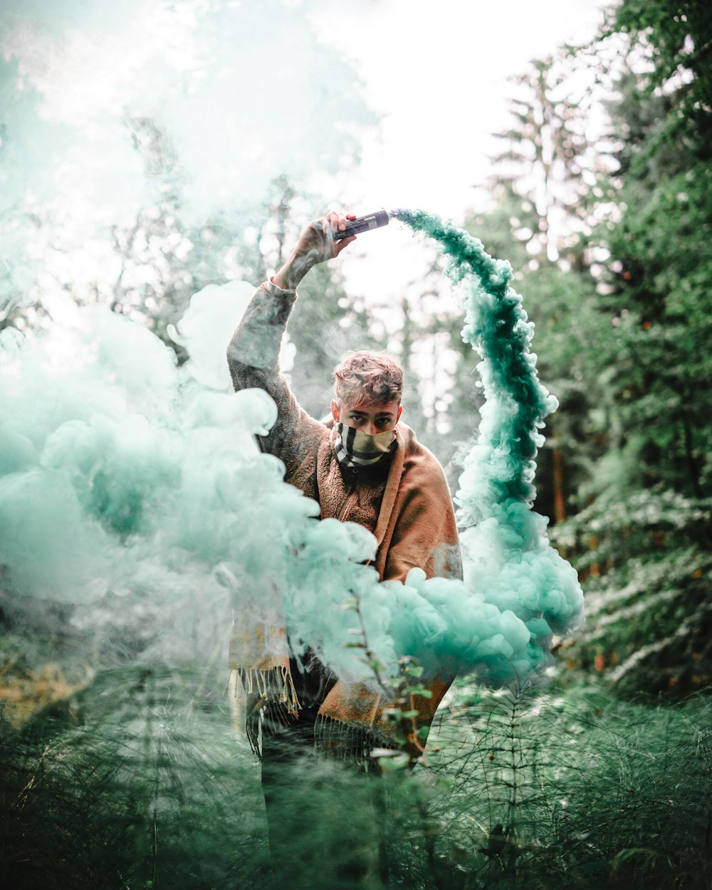 man holding blue ash smoke