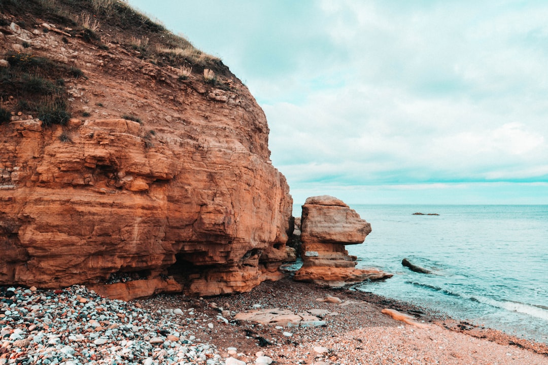 brown rocky mountain beside beach