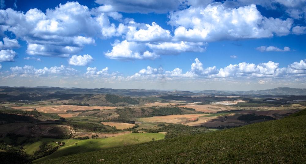 aerial photography of mountain and field during cloudy sky