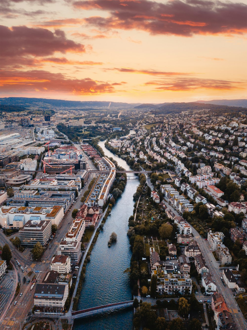 fotografia aerea del lago tra gli edifici della città durante l'alba