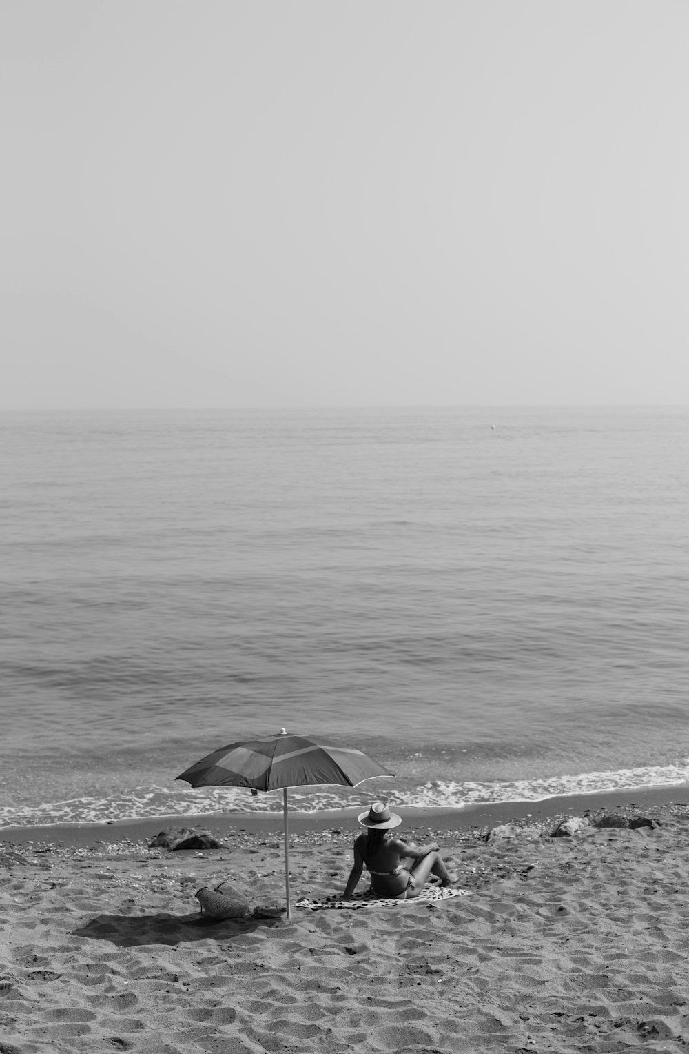 person sitting on shore near body of water