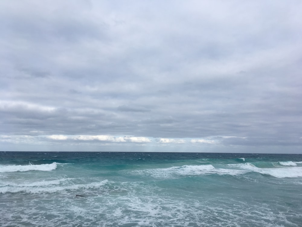 blue beach under gray sky