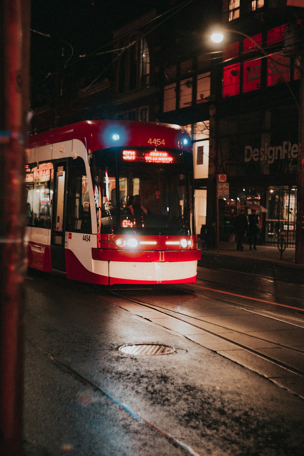 red and white tram beside design shop front