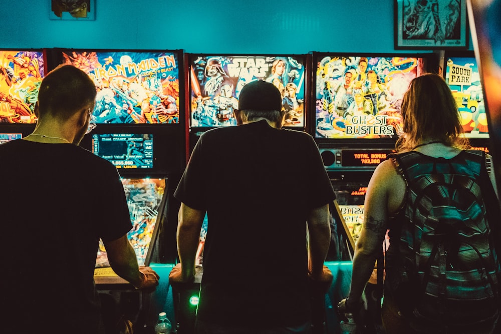 pessoas jogando máquinas de arcade