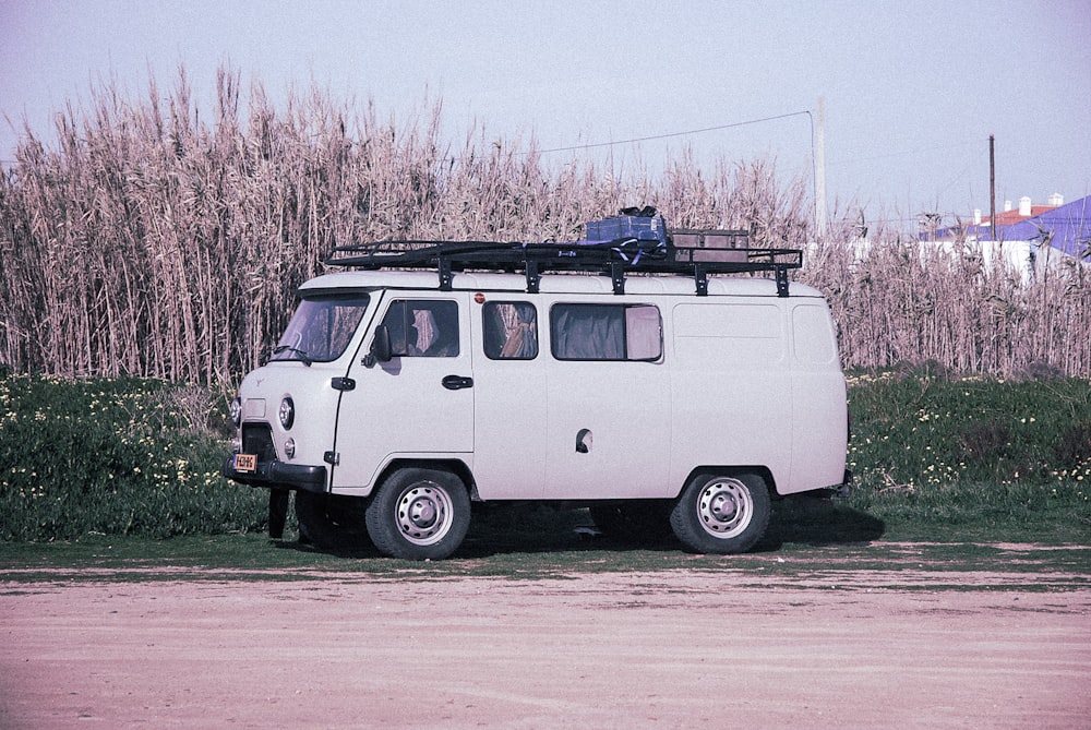 white van parking beside dried grass