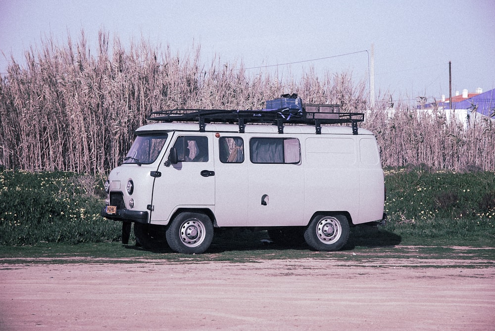 Aparcamiento de furgonetas blancas junto a hierba seca