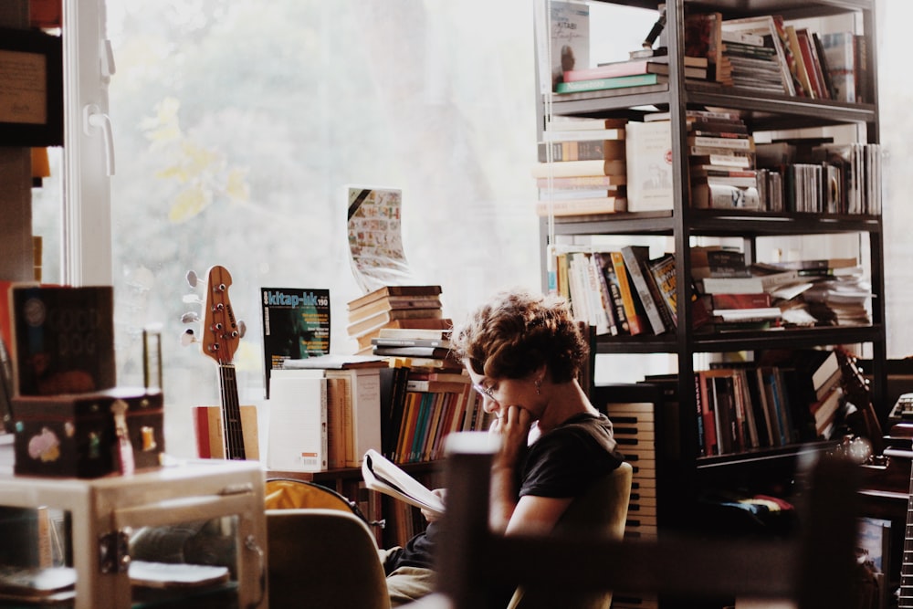 woman reading book sitting beside electronic keyboard