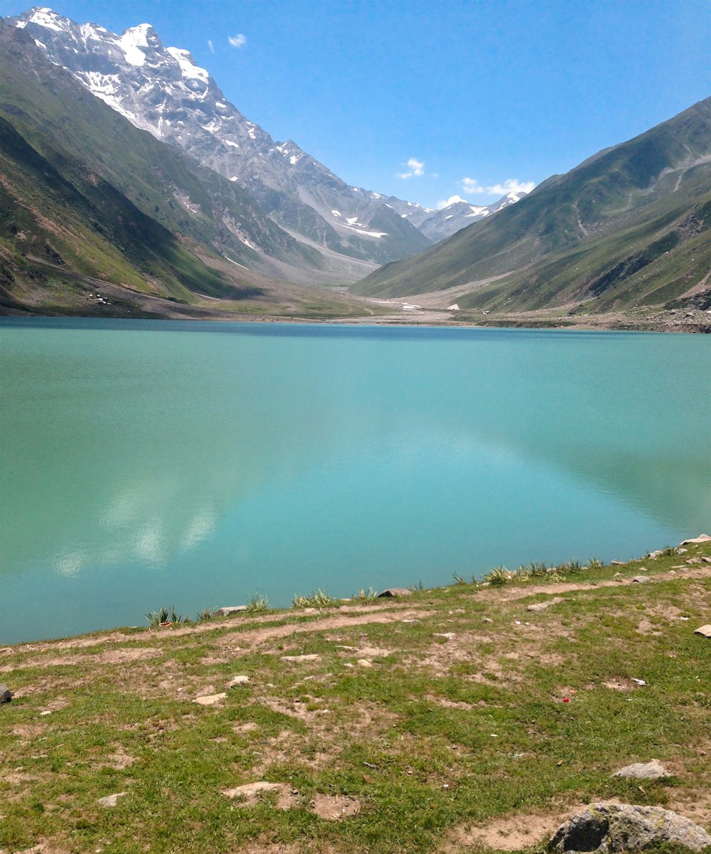 calm body of water near mountain s