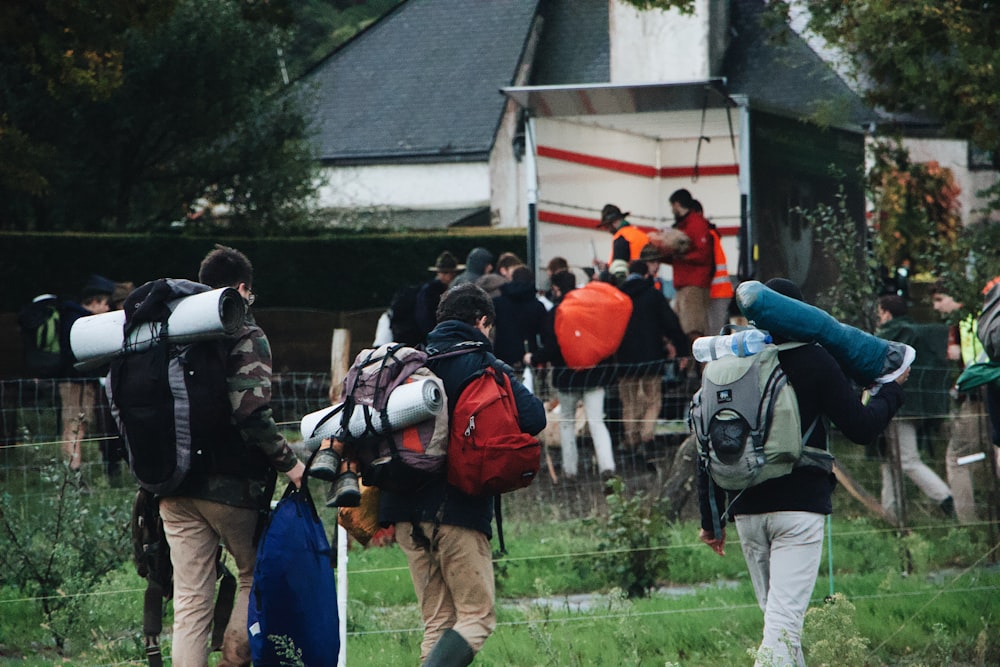 men carrying bags walking near house