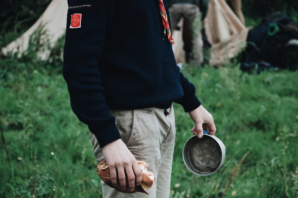 person holding bread and gray metal bowl